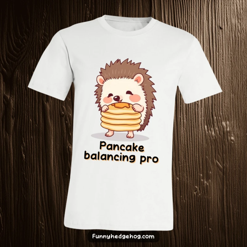 Funny T-shirt with a charming hedgehog struggling to balance a teetering stack of pancakes, exuding playful determination and humor.